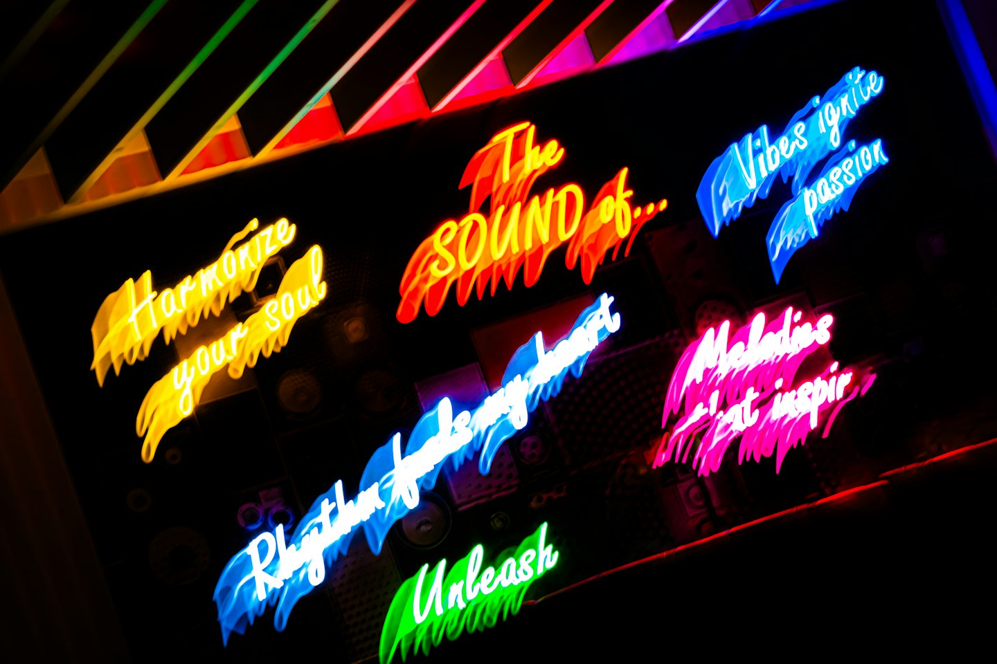 Bright neon signs with inspirational and music phrases glow.